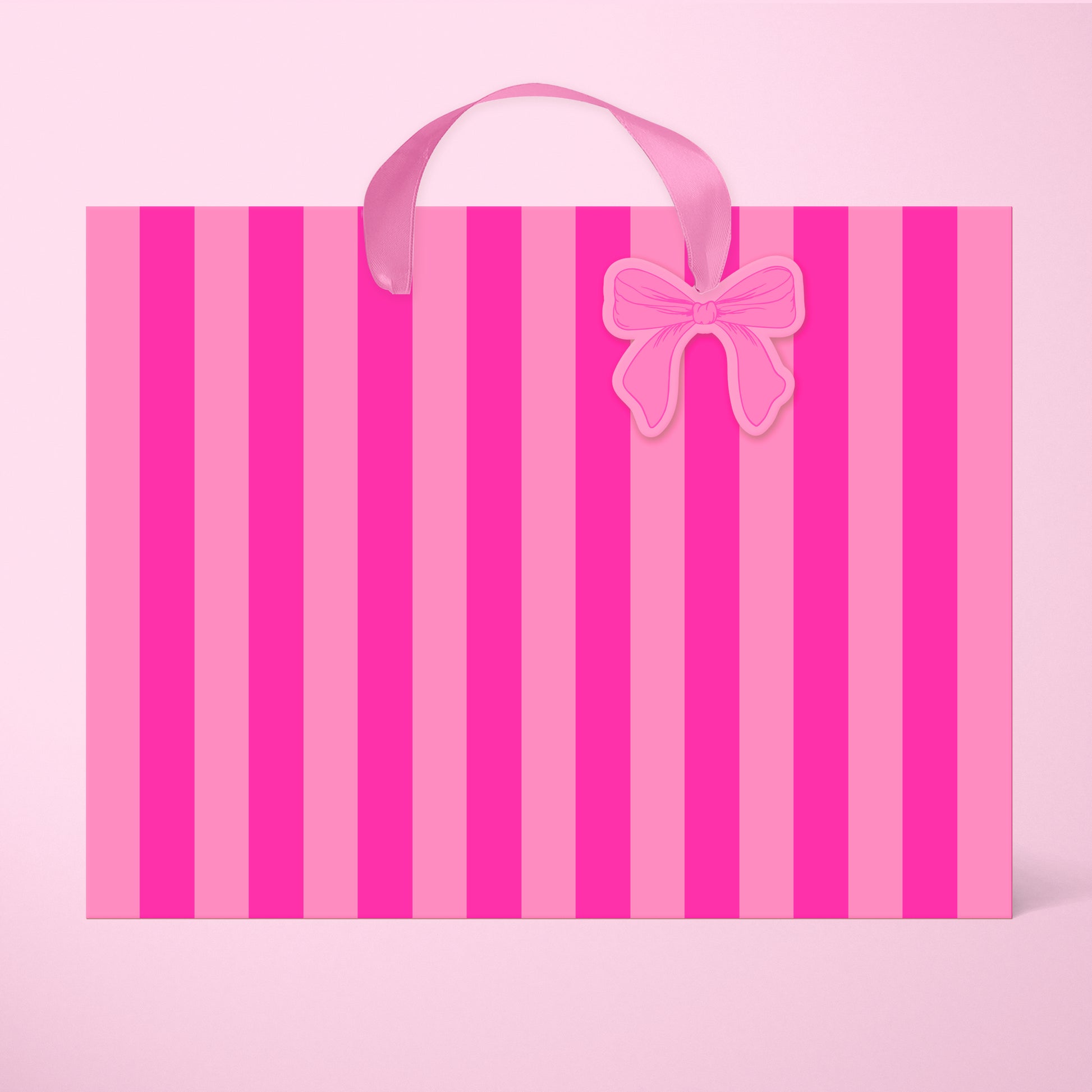 A light pink and hot pink striped gift bag in two different sizes with ribbon handles and a small bow shaped tag.