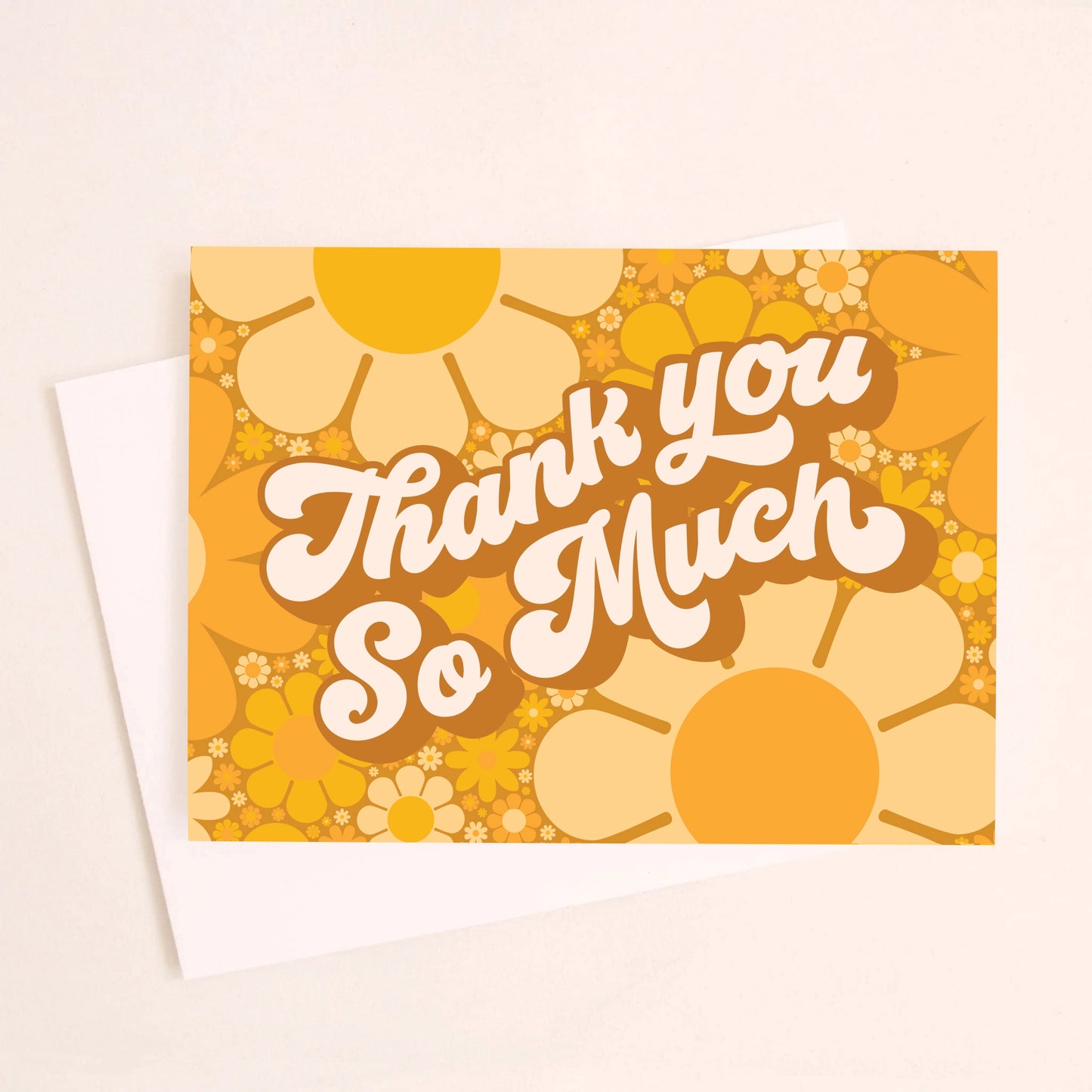 On an ivory background is a daisy printed thank you card with shades of orange and yellow along with white text in the center that reads, "Thank You So Much". 