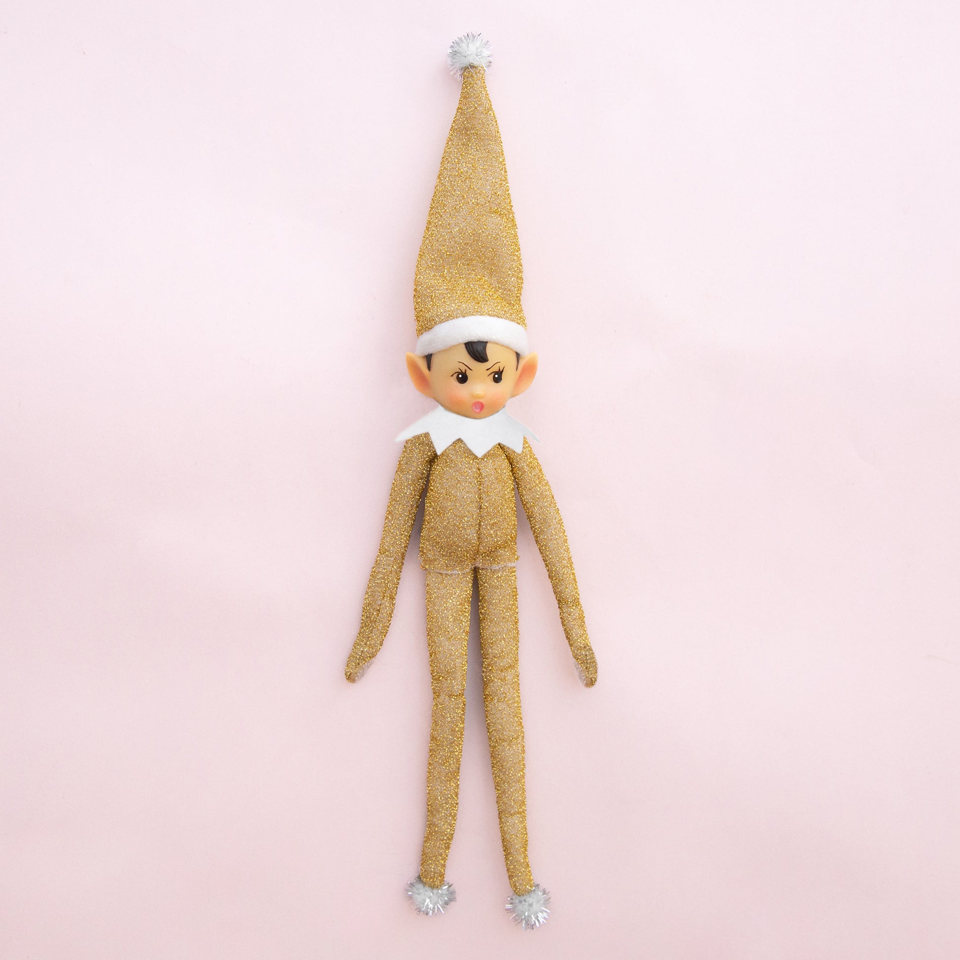 A gold sparkled elf shaped ornament. 