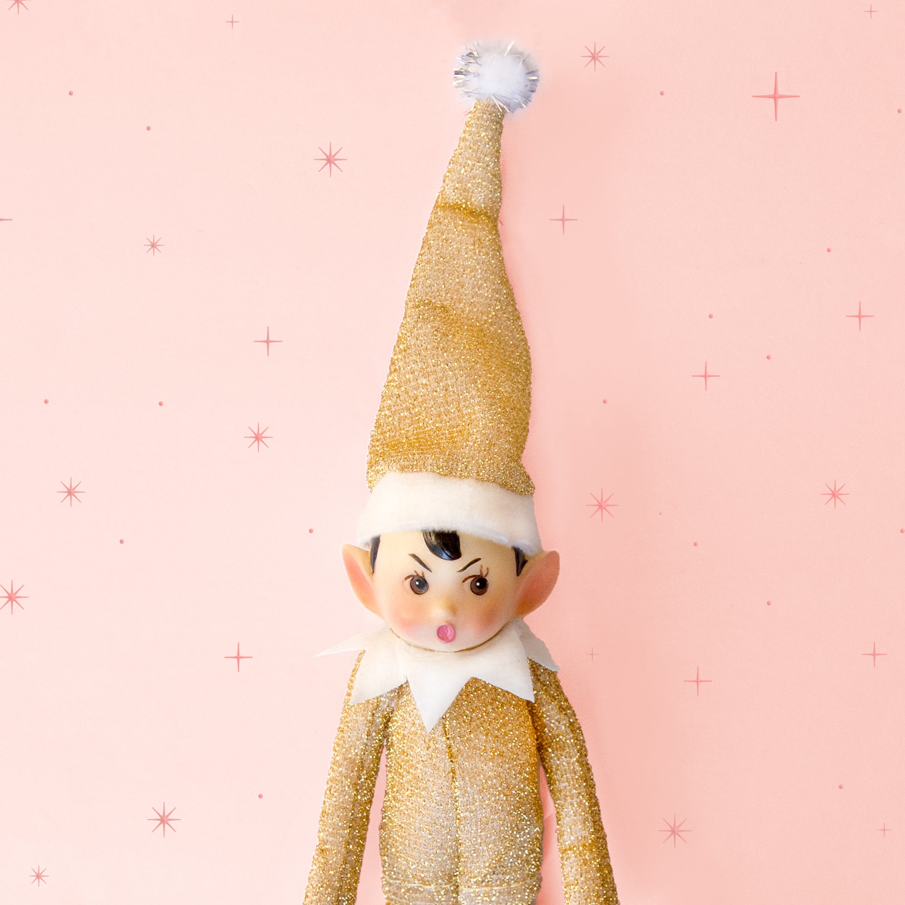A gold sparkled elf shaped ornament. 