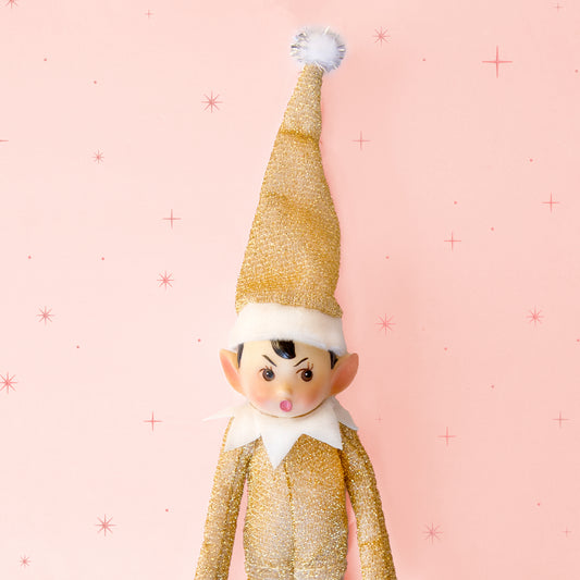 A gold sparkled elf shaped ornament. 