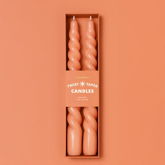 A pair of orange twisted taper candles. 
