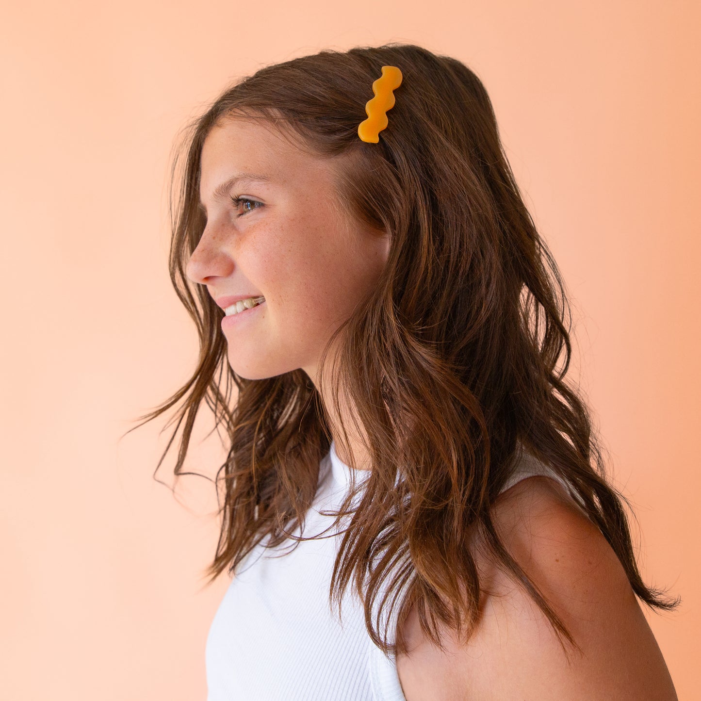 Two wavy hair clips in a tangerine shade and a pink color.