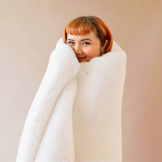 An ivory white faux fur blanket. 