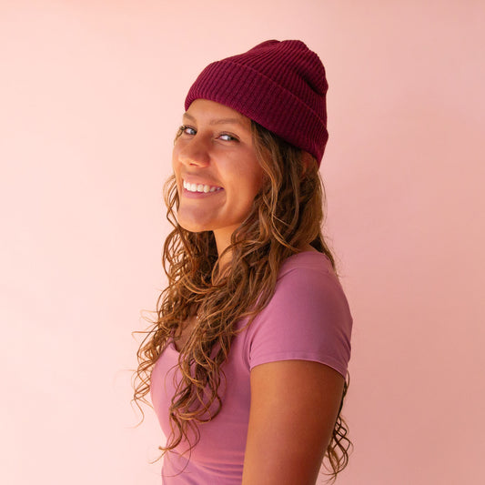 A model wearing the plum shade of the Billie beanie. 