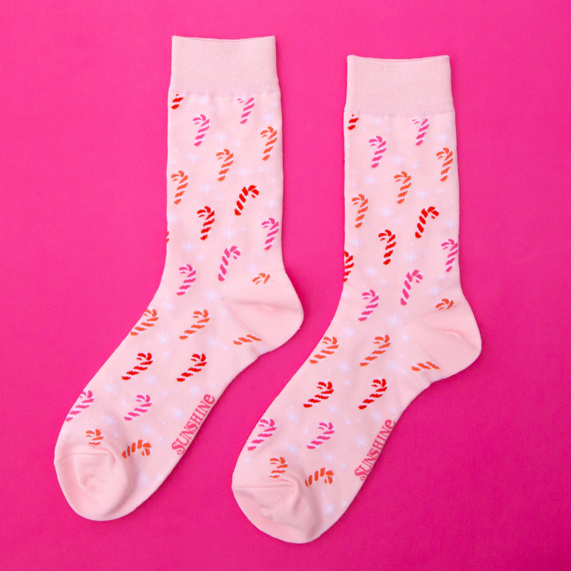 A pair of pink crew socks with a pink cotton candy pattern. 