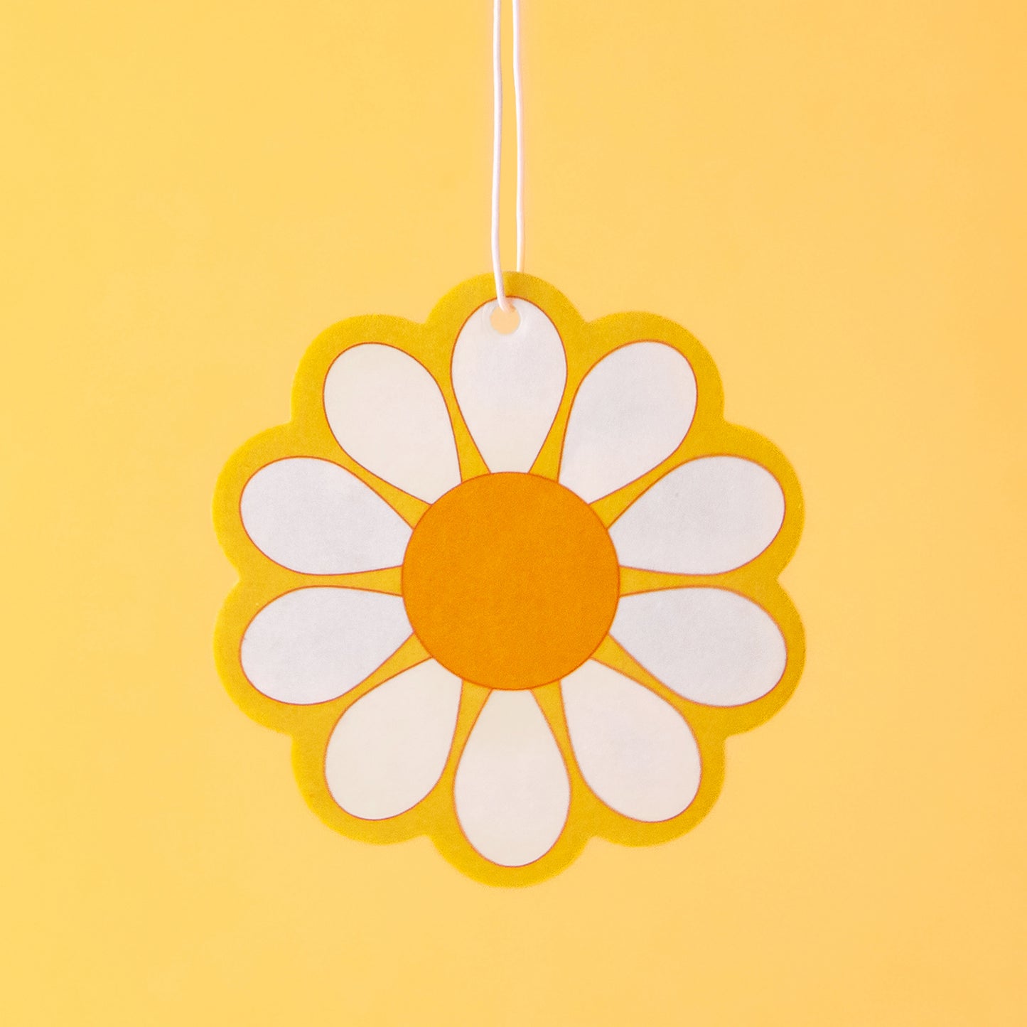 A yellow, white and orange daisy shaped air freshener. 