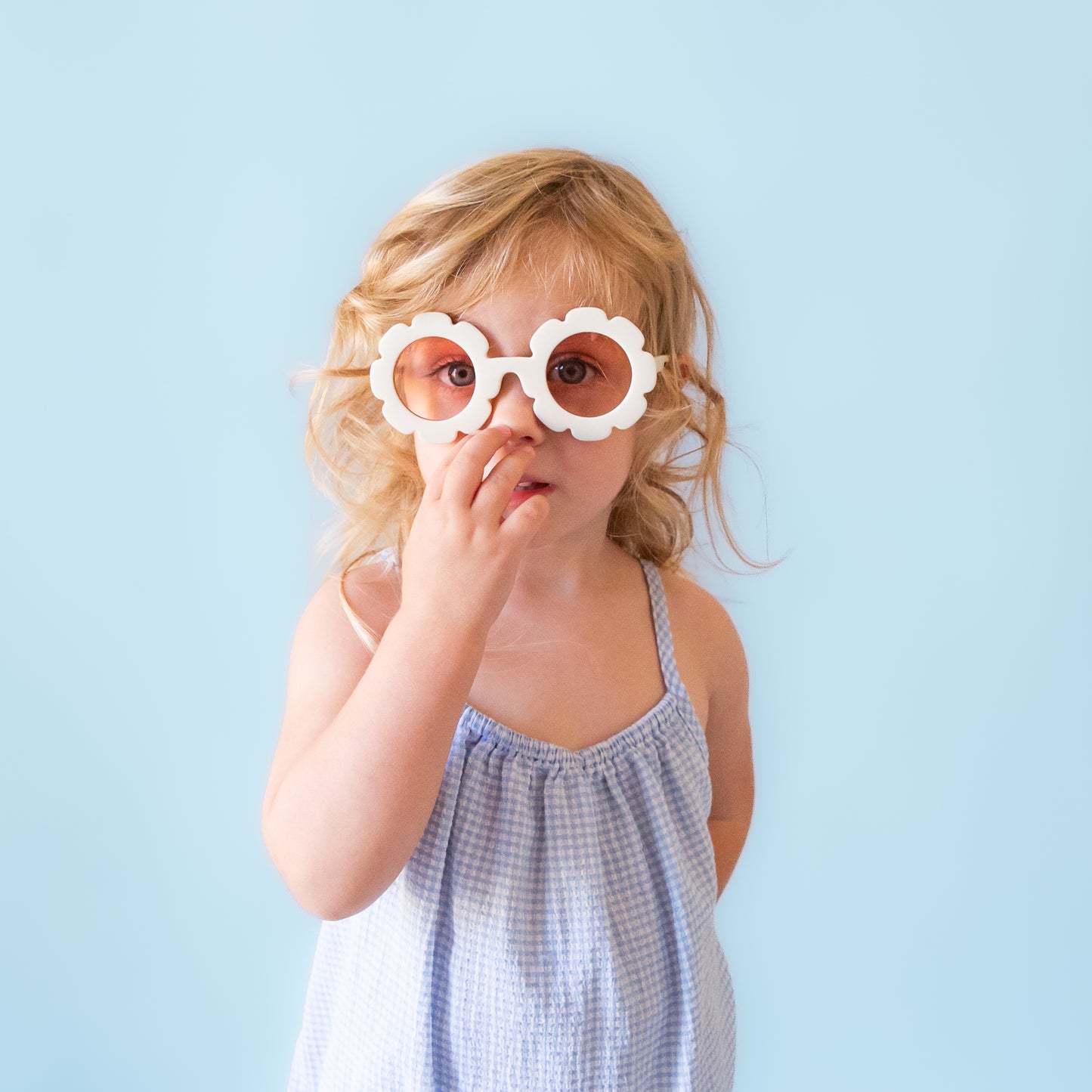 White flower sunglasses with a pink lens.