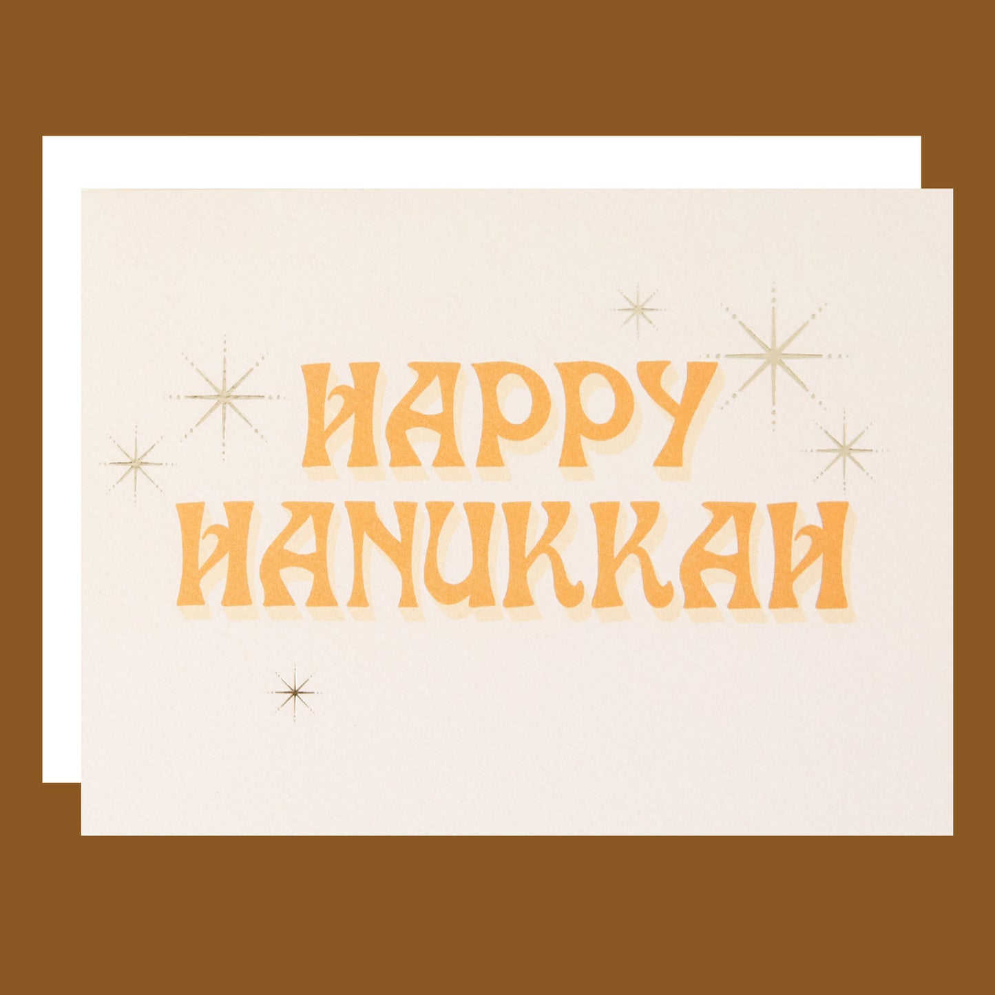 Ivory card that reads 'Happy Hanukkah' in retro orange lettering. The text is accented with gold foil stars twinkling around.