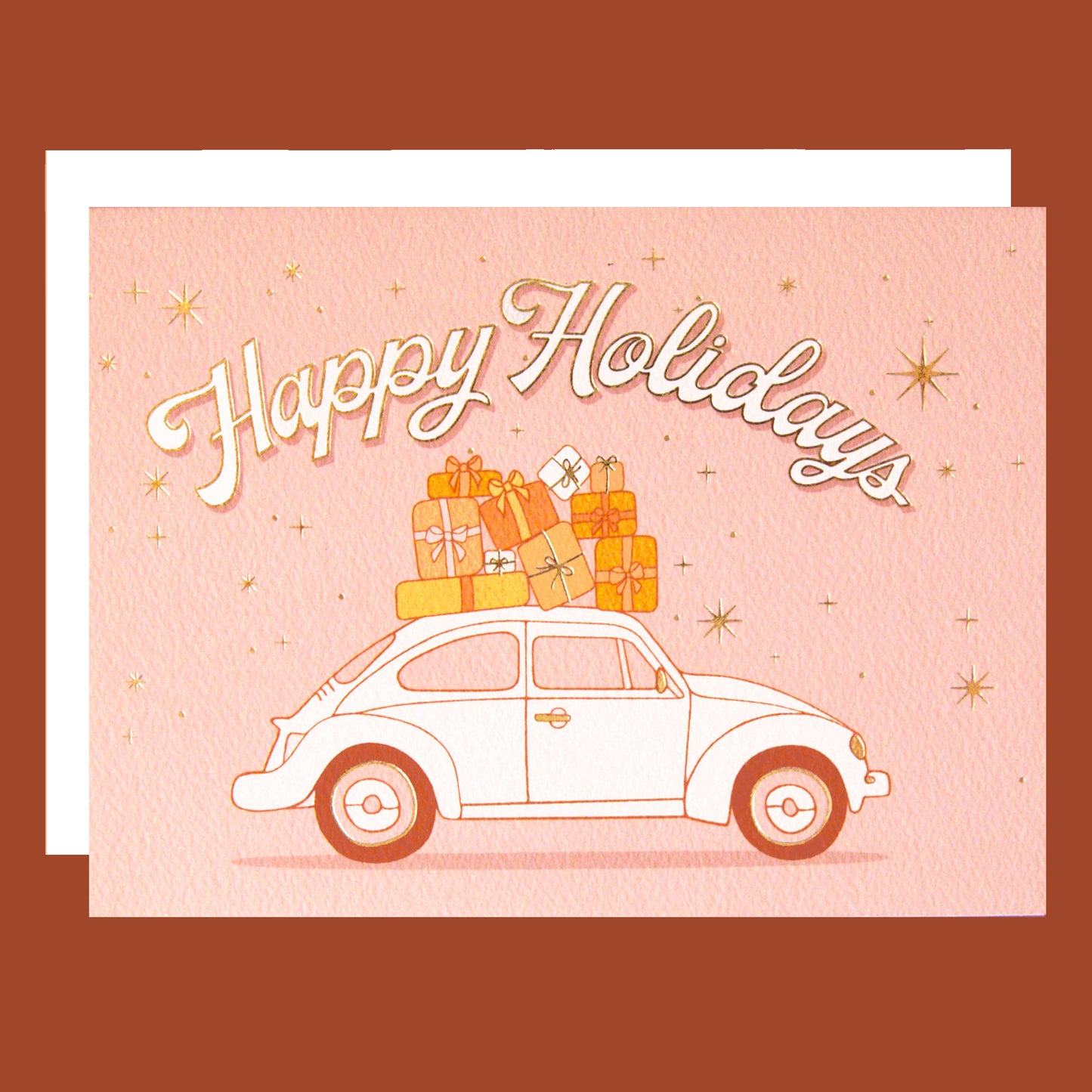 On a pink background is a card with a VW bug with gifts on top and text arched above it that reads, "Happy Holidays".