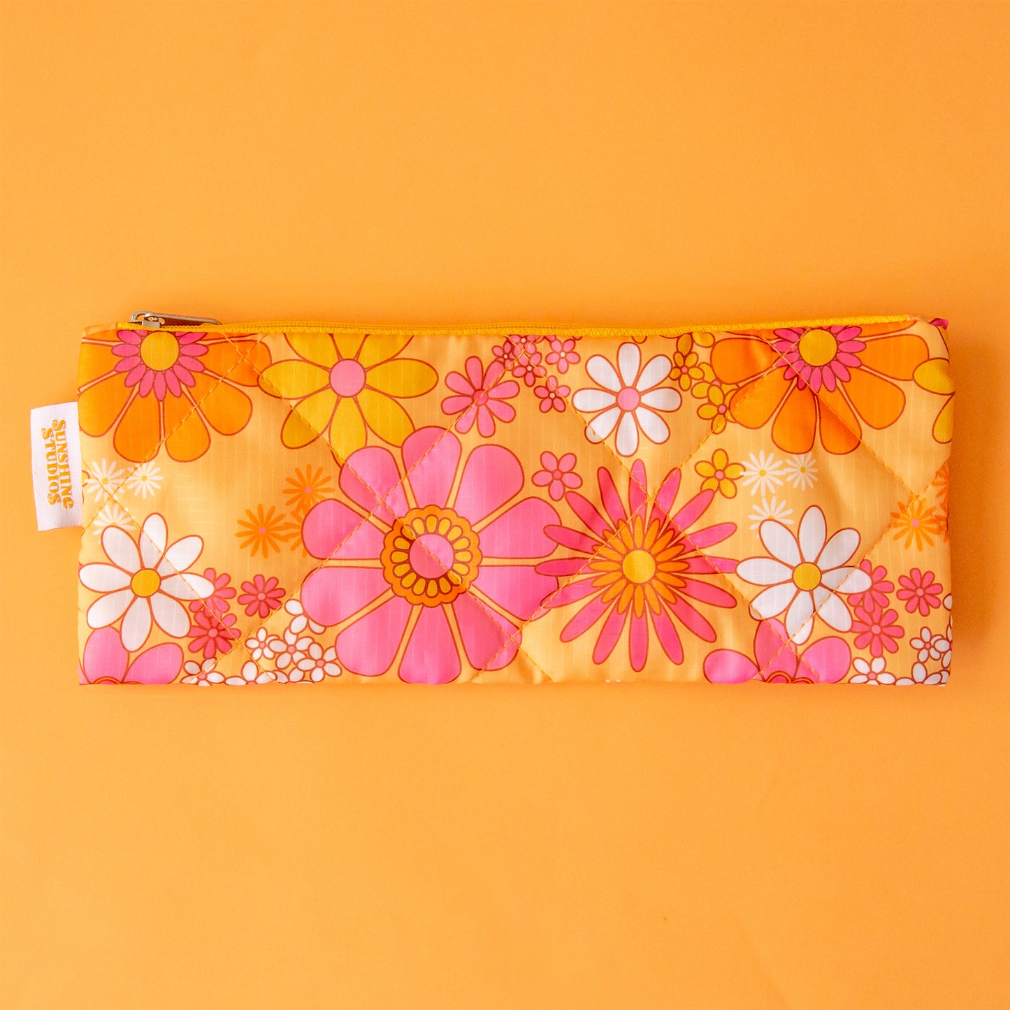 A floral print pencil pouch in orange, pink and ivory tones.