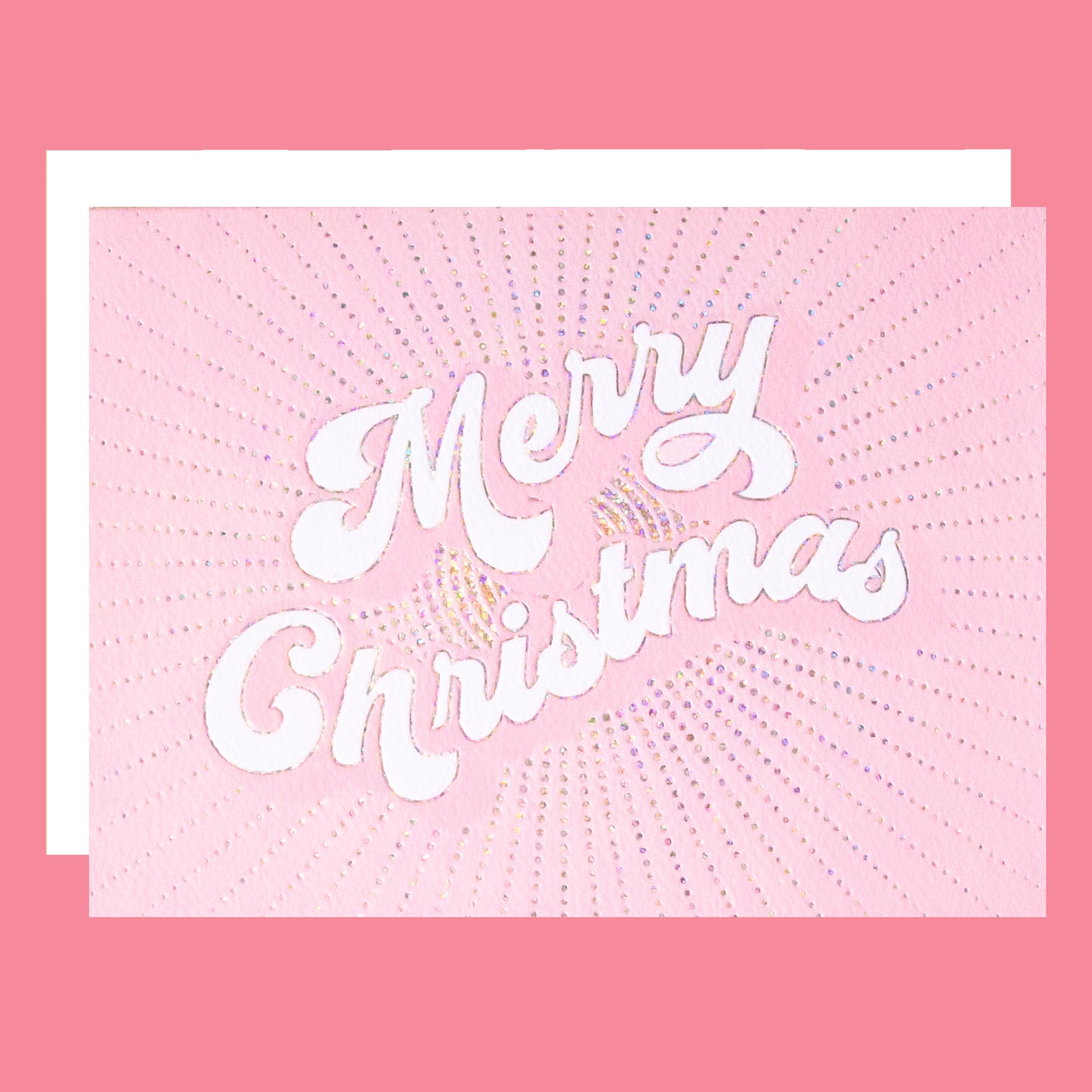 a light pink greeting card with white text in the center that reads, "Merry Christmas" along with a white envelope. 