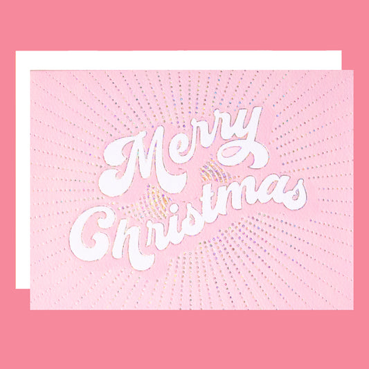 a light pink greeting card with white text in the center that reads, "Merry Christmas" along with a white envelope. 