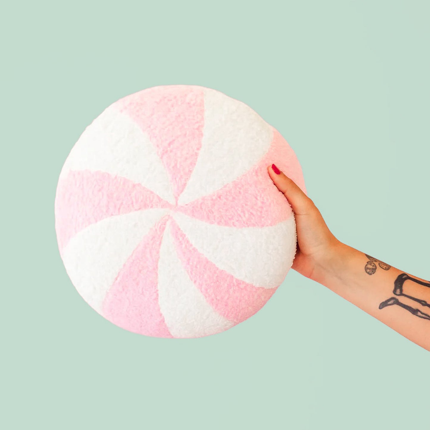 A light pink and white circle swirl pillow. 