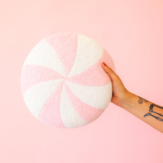 A light pink and white circle swirl pillow. 