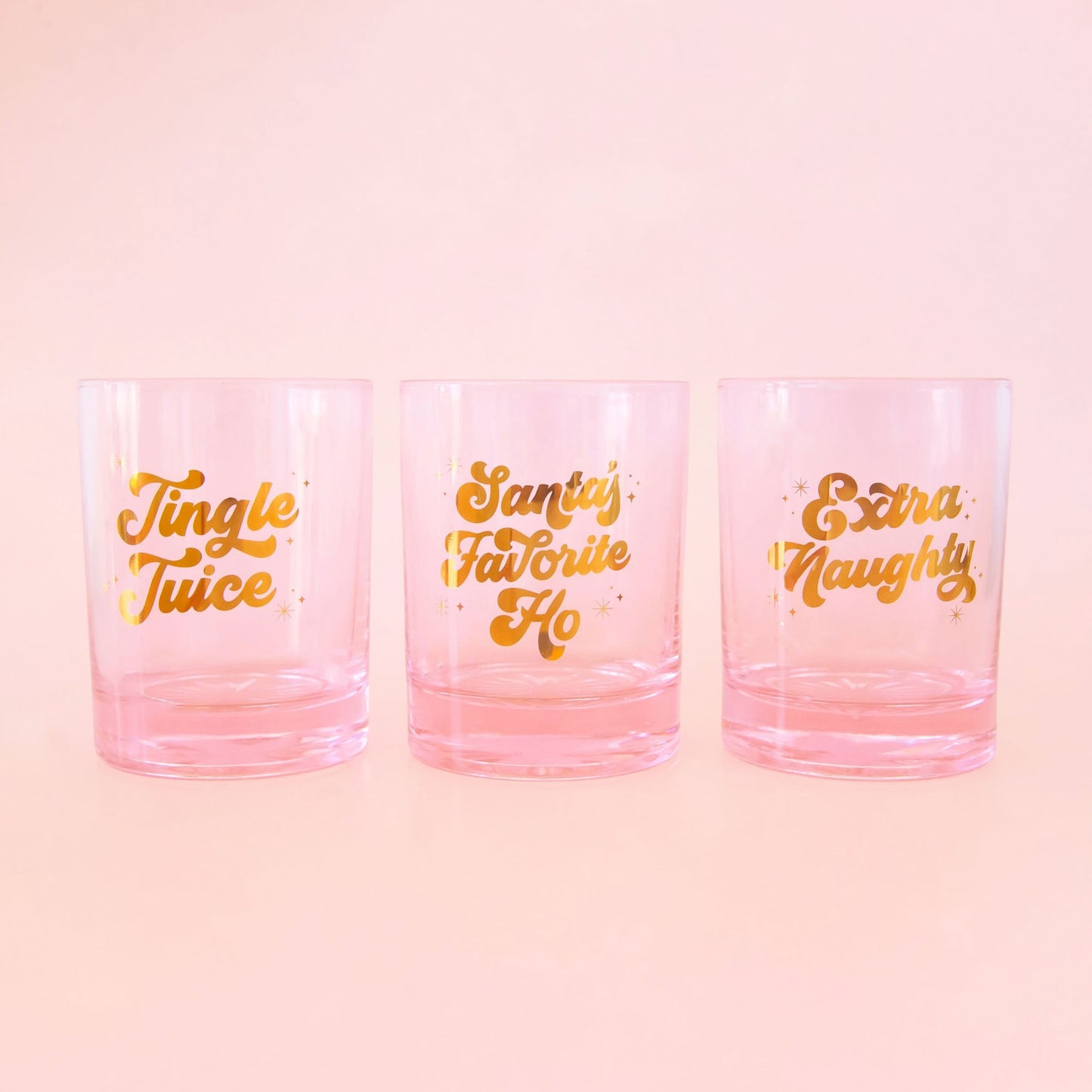 All three pink glass tumblers. One reads, "Jingle Juice", "Santa's Favorite Ho", "Extra Naughty". 