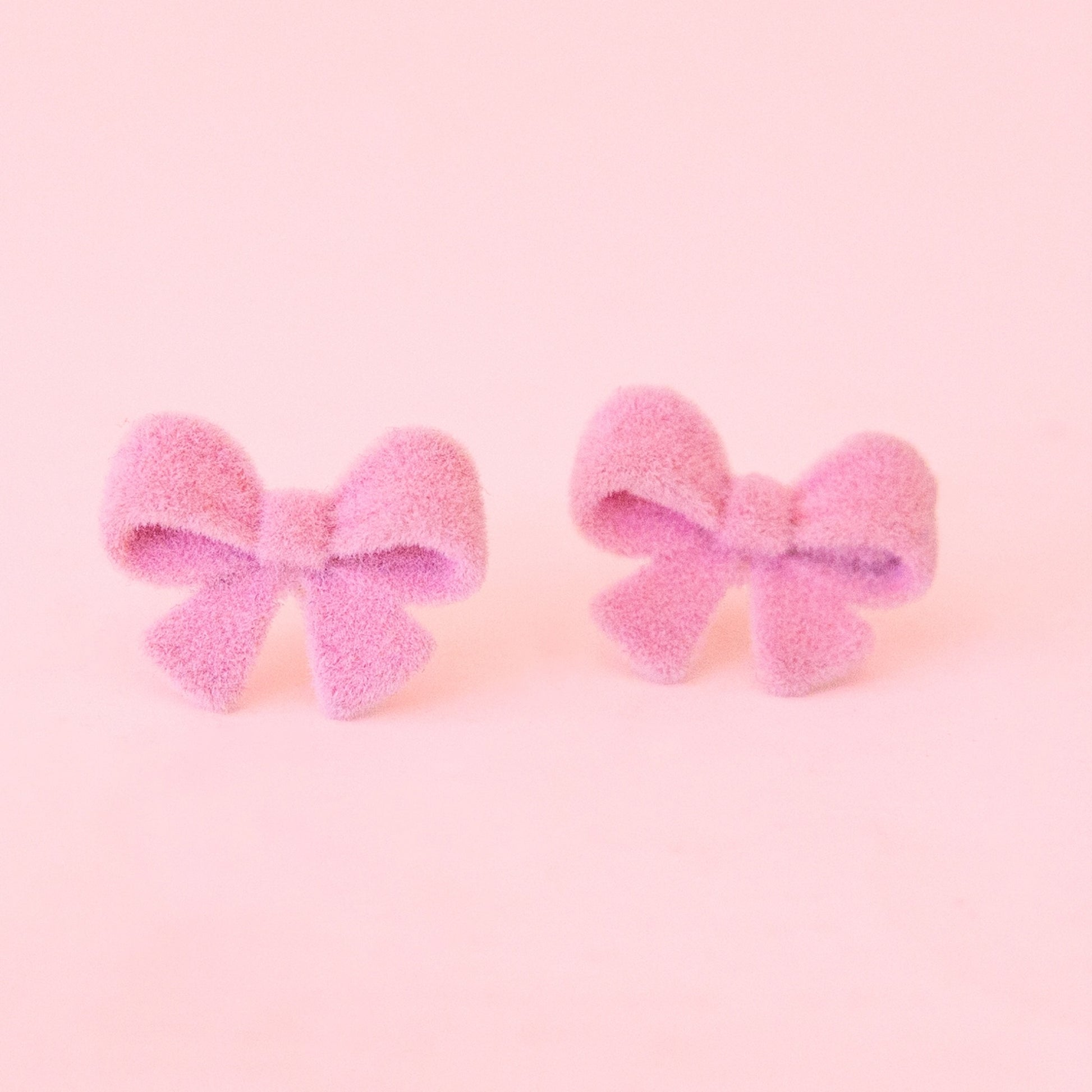 Pair of pink bow earrings.