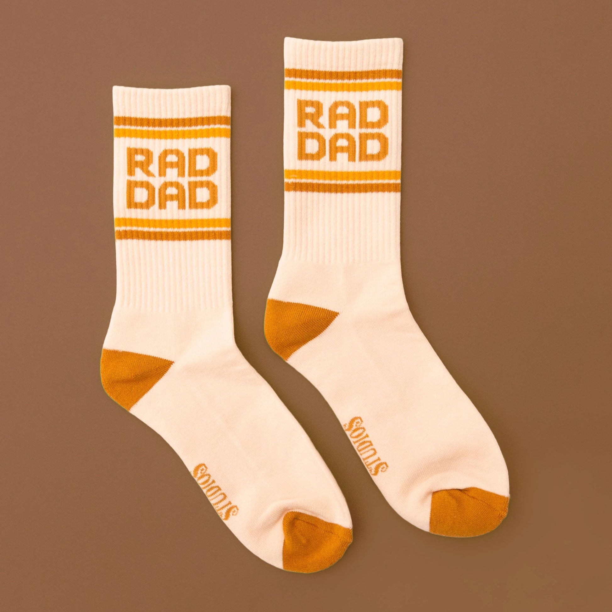 cream colored socks with gold accents and "rad dad" along the top