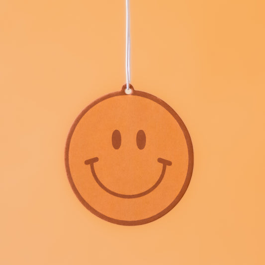 A yellow smiley face car air freshener.