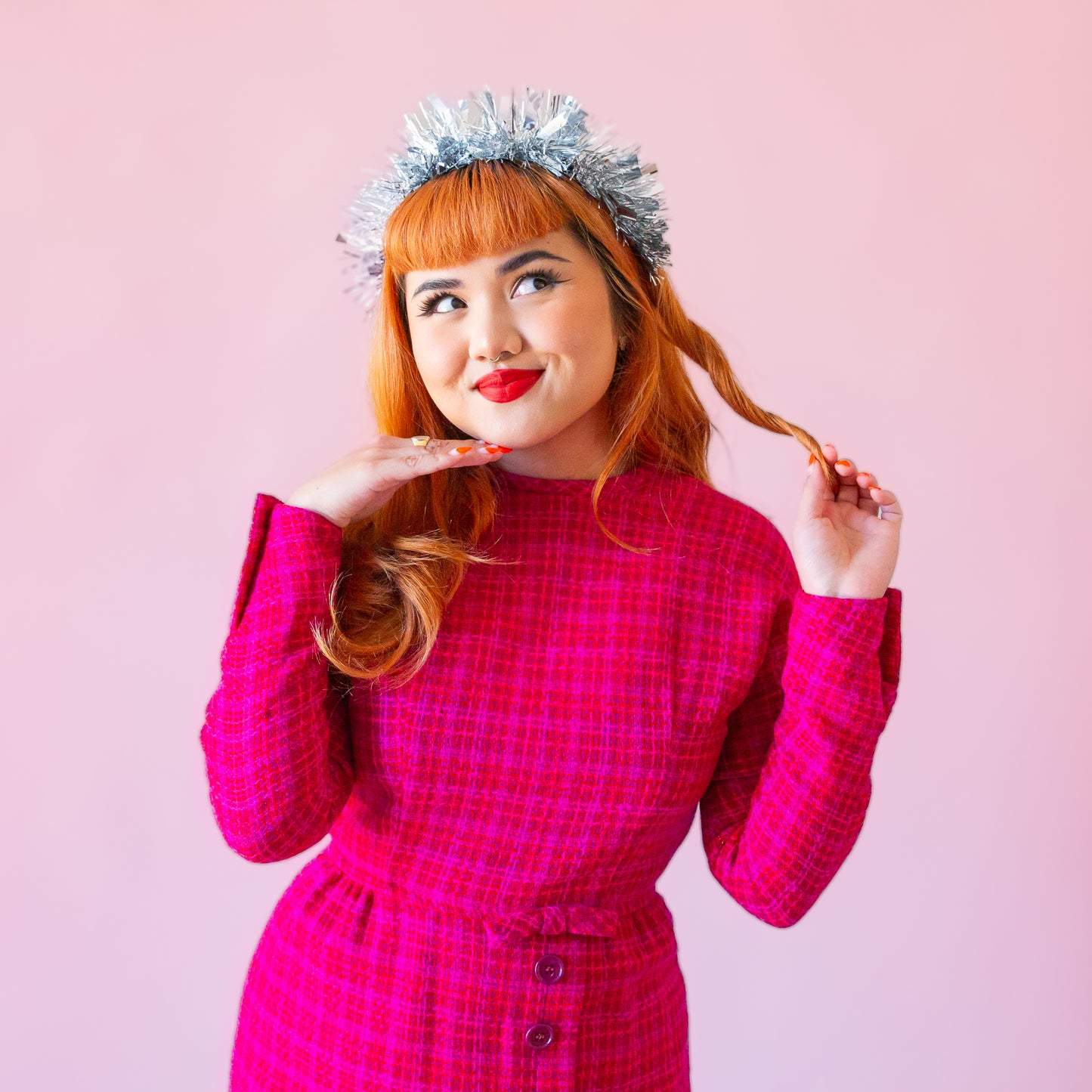 A model wearing a silver tinsel headband. 
