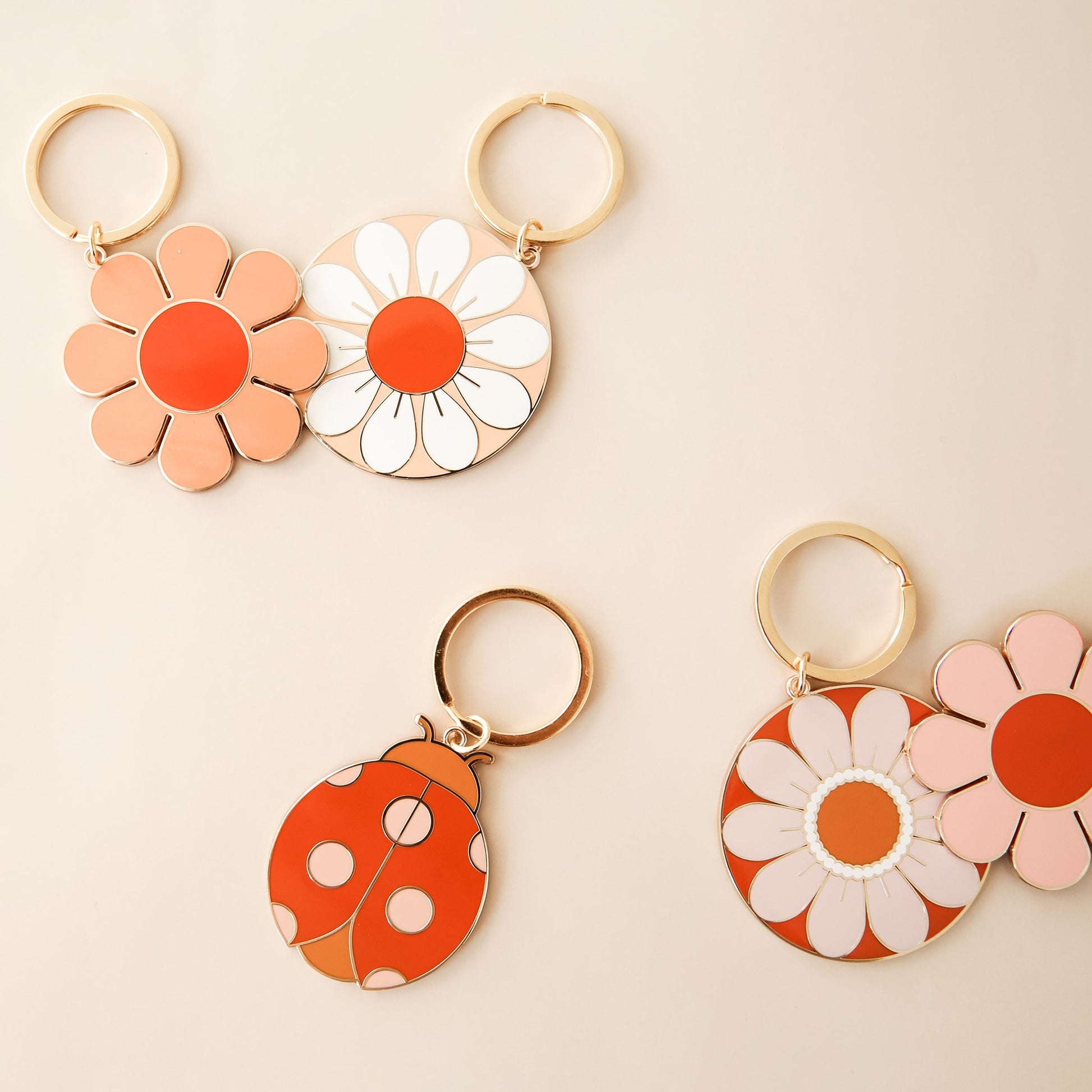 Five retro-inspired keychains including a variety of flowers and a ladybug.