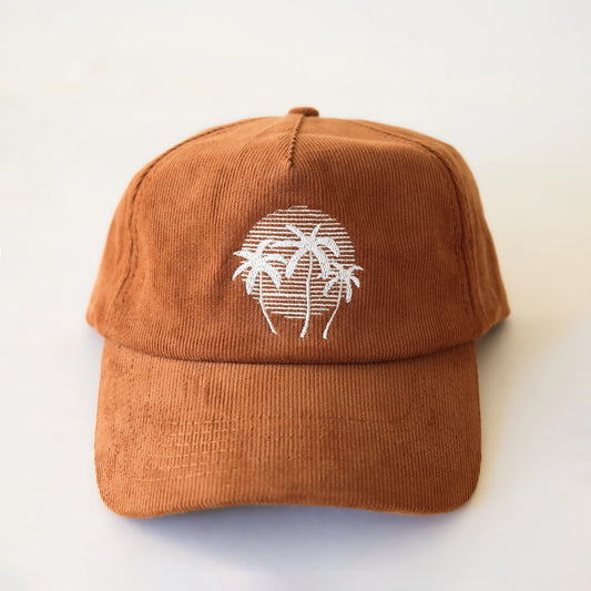 A terracotta colored corduroy baseball hat with a palm tree graphic in the center.