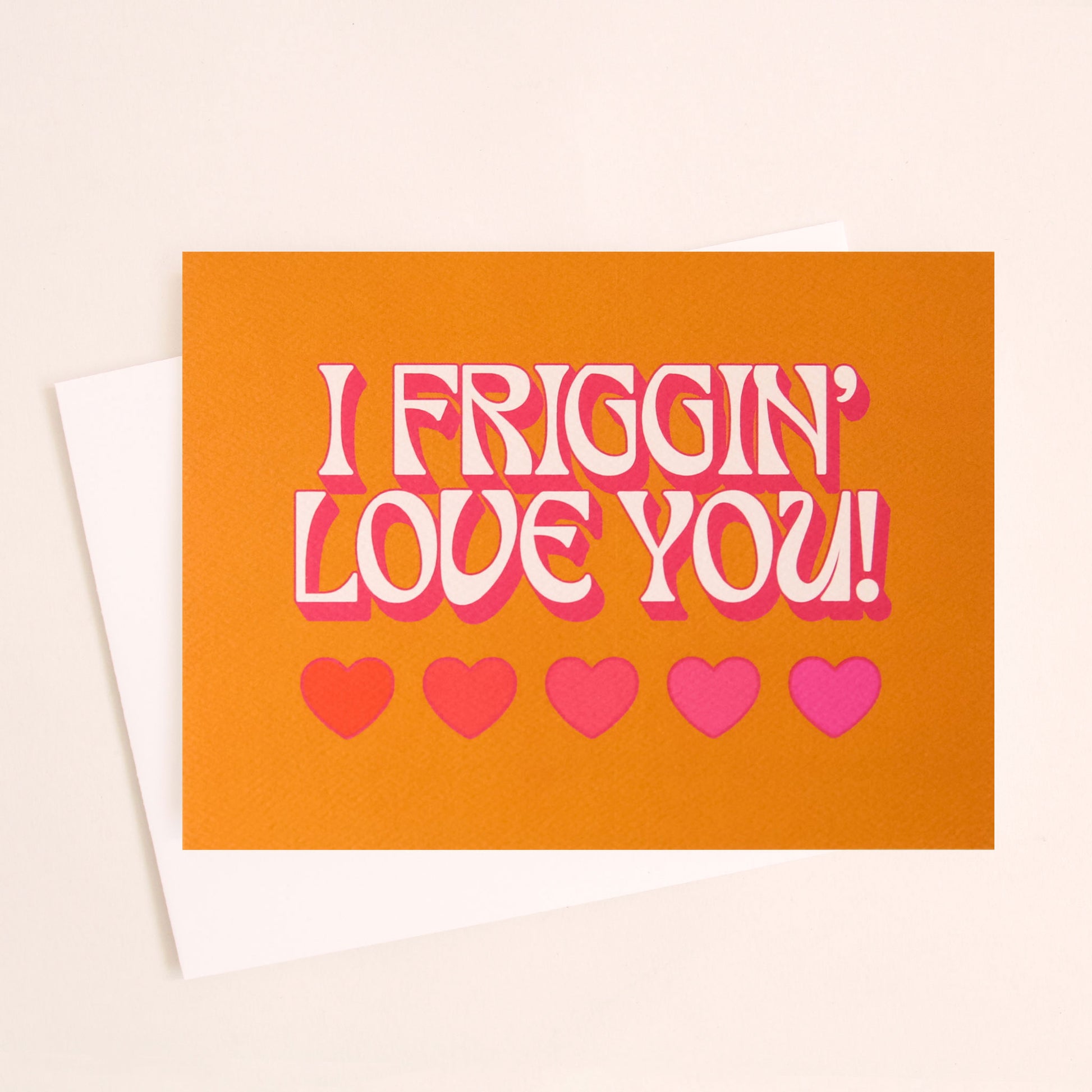 Burnt orange card that reads 'I friggin' love you!' in white text with a thin pink shadow. Below the text are five hearts in various shades of pink.