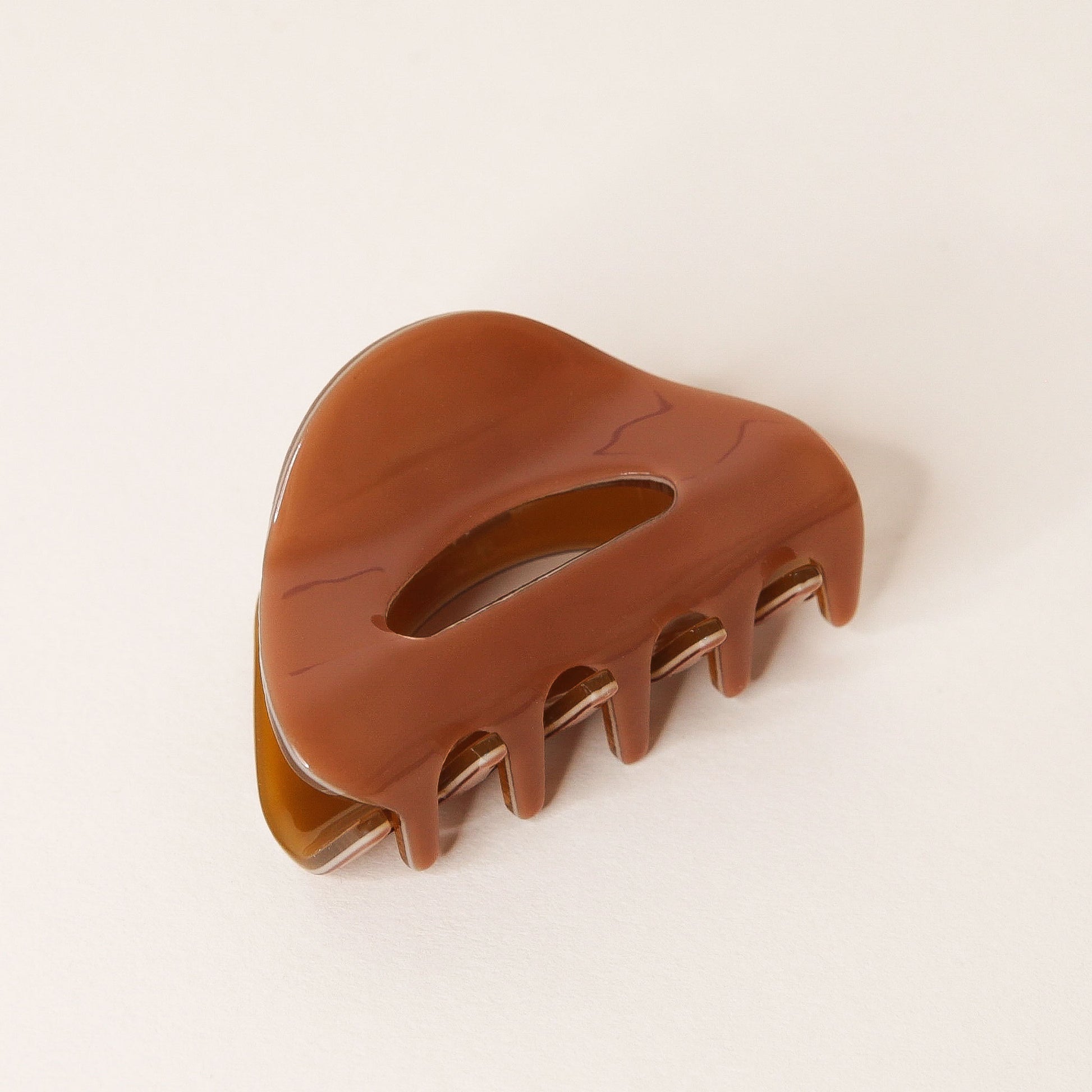 Chocolate brown claw hair clip with rounded edges and two simple oval cutouts.