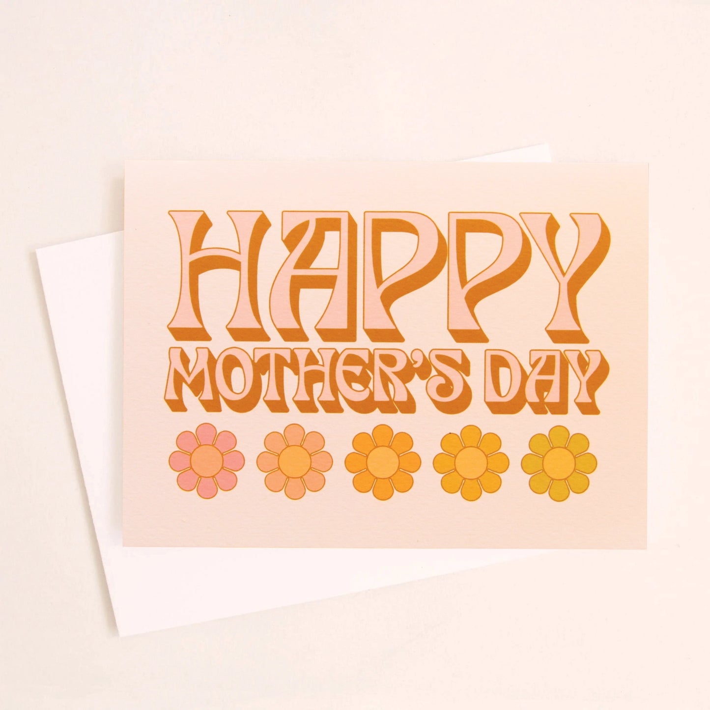 A light tangerine card with text that reads, "Happy Mother's Day" in orange letters and give daisy graphics along the bottom of the card as well as a white envelope.