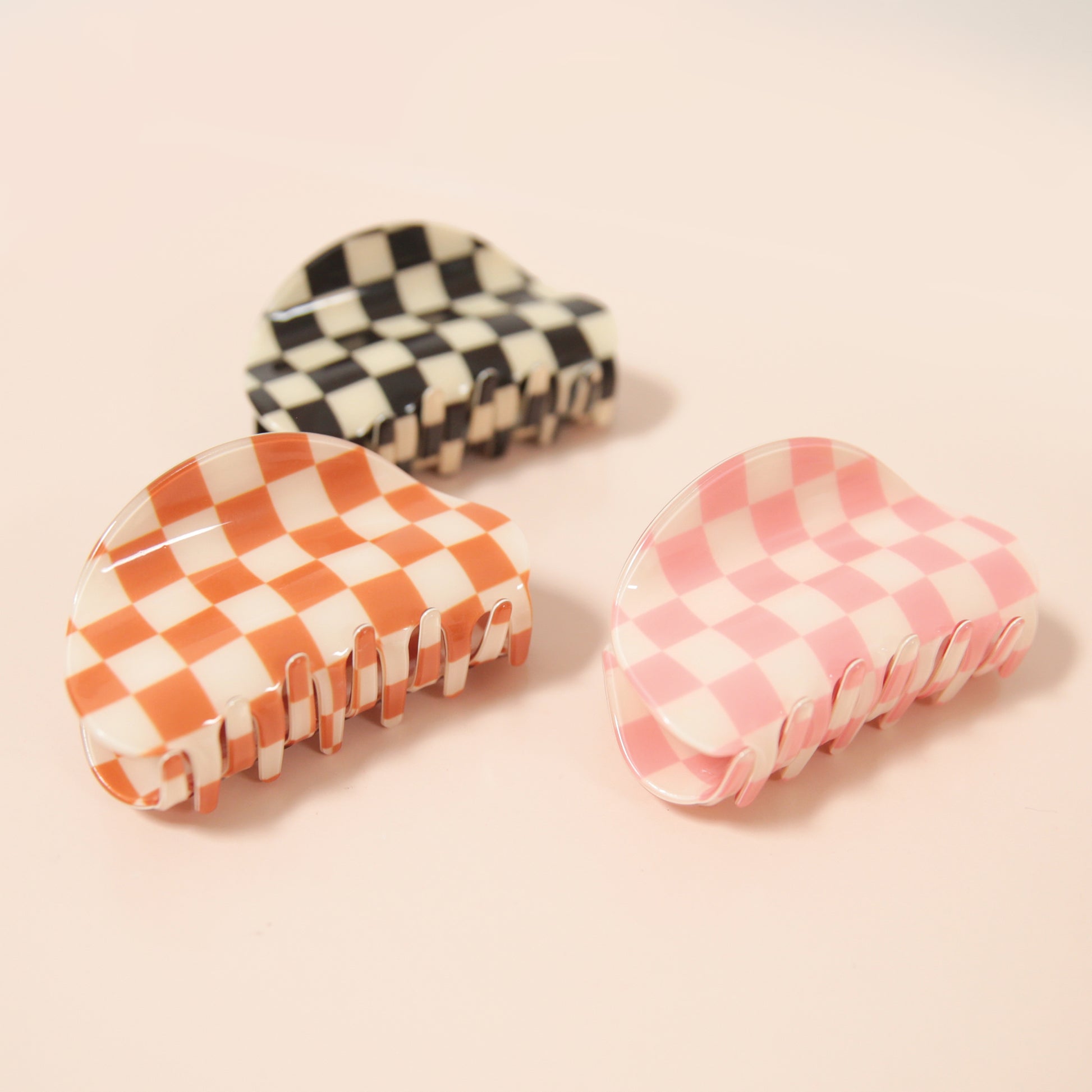A pink and white checkered claw clip with a rounded edge detail.