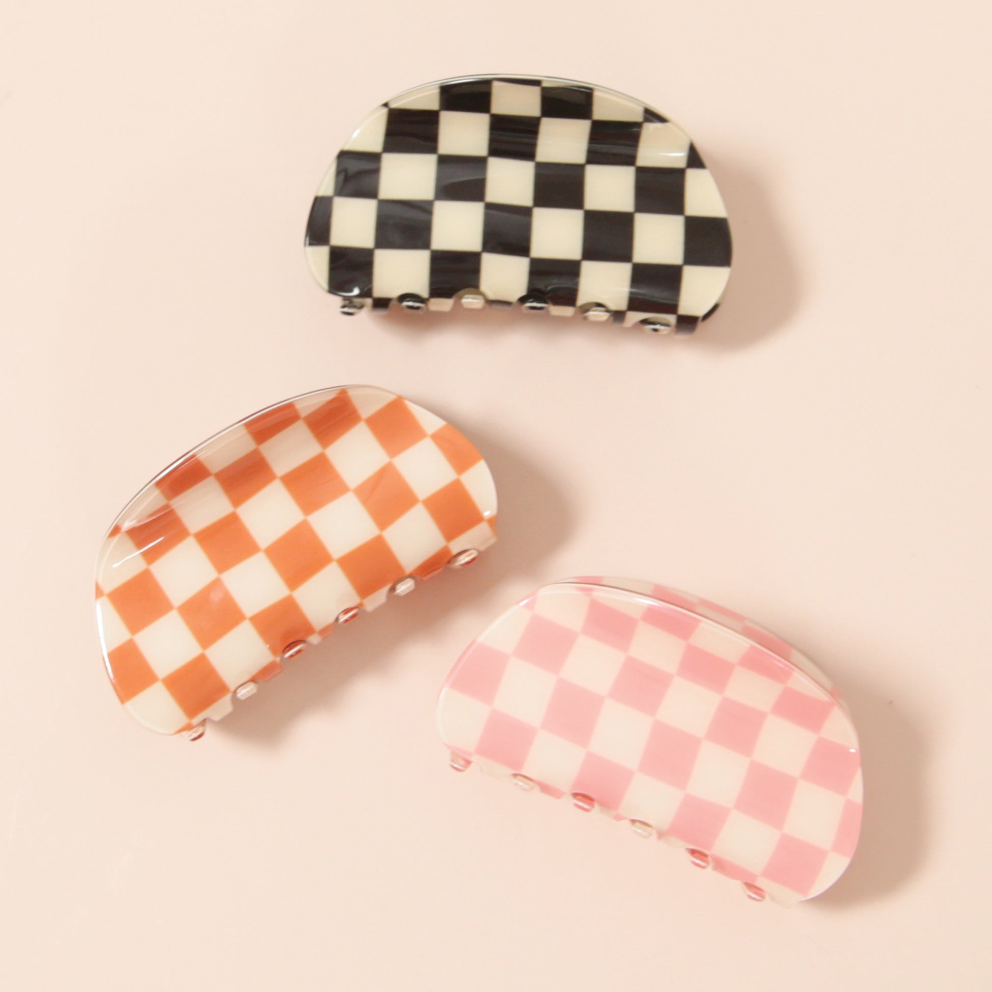 A pink and white checkered claw clip with a rounded edge detail.