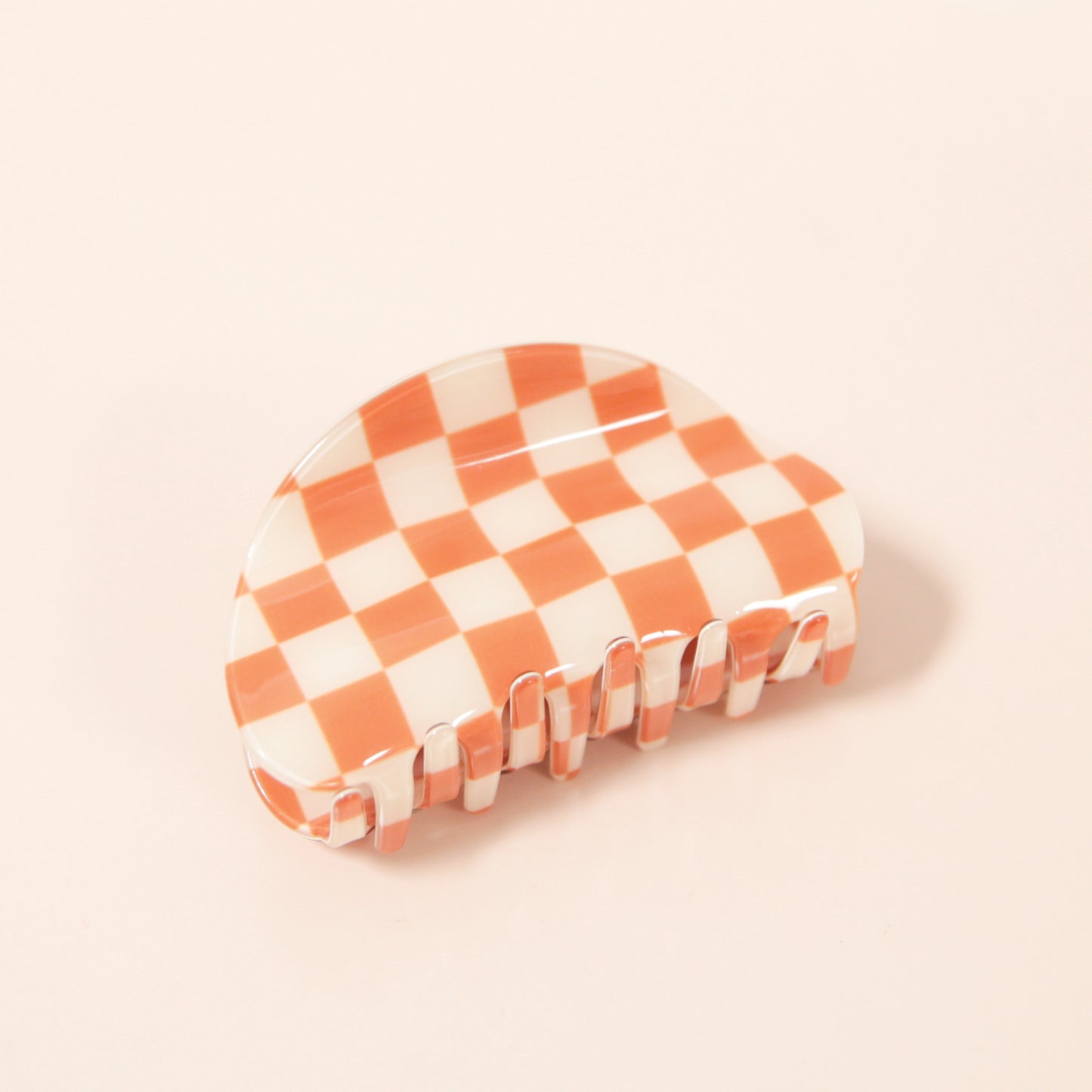 An orange and white claw clip with a rounded edge detail.