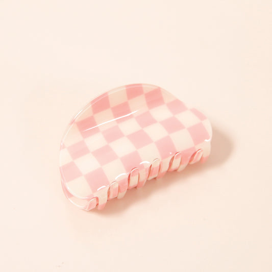 A pink and white checkered claw clip with a rounded edge detail.