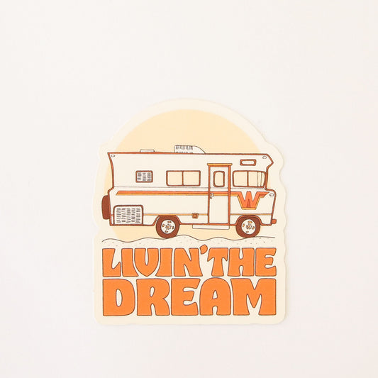 Retro inspired sticker featuring a old school RV camper with orange and yellow detailing. Below the van reads 'Livin' the dream' in orange capital bubble letters. 