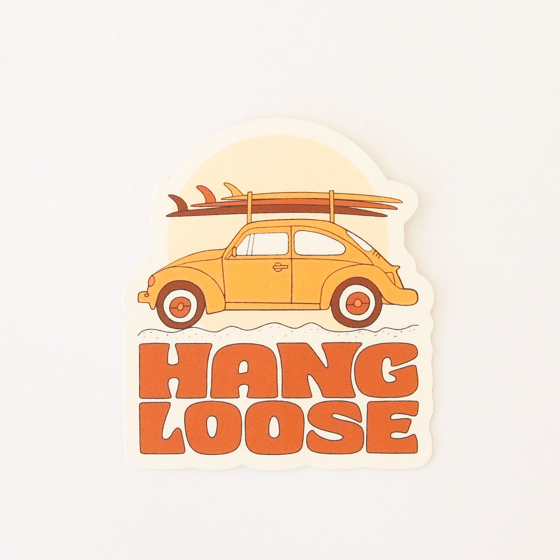 70s inspired sticker featuring a classic orange VW bug stacked with three surf boards. Below reads 'Hang loose' in orange capital bubble lettering.