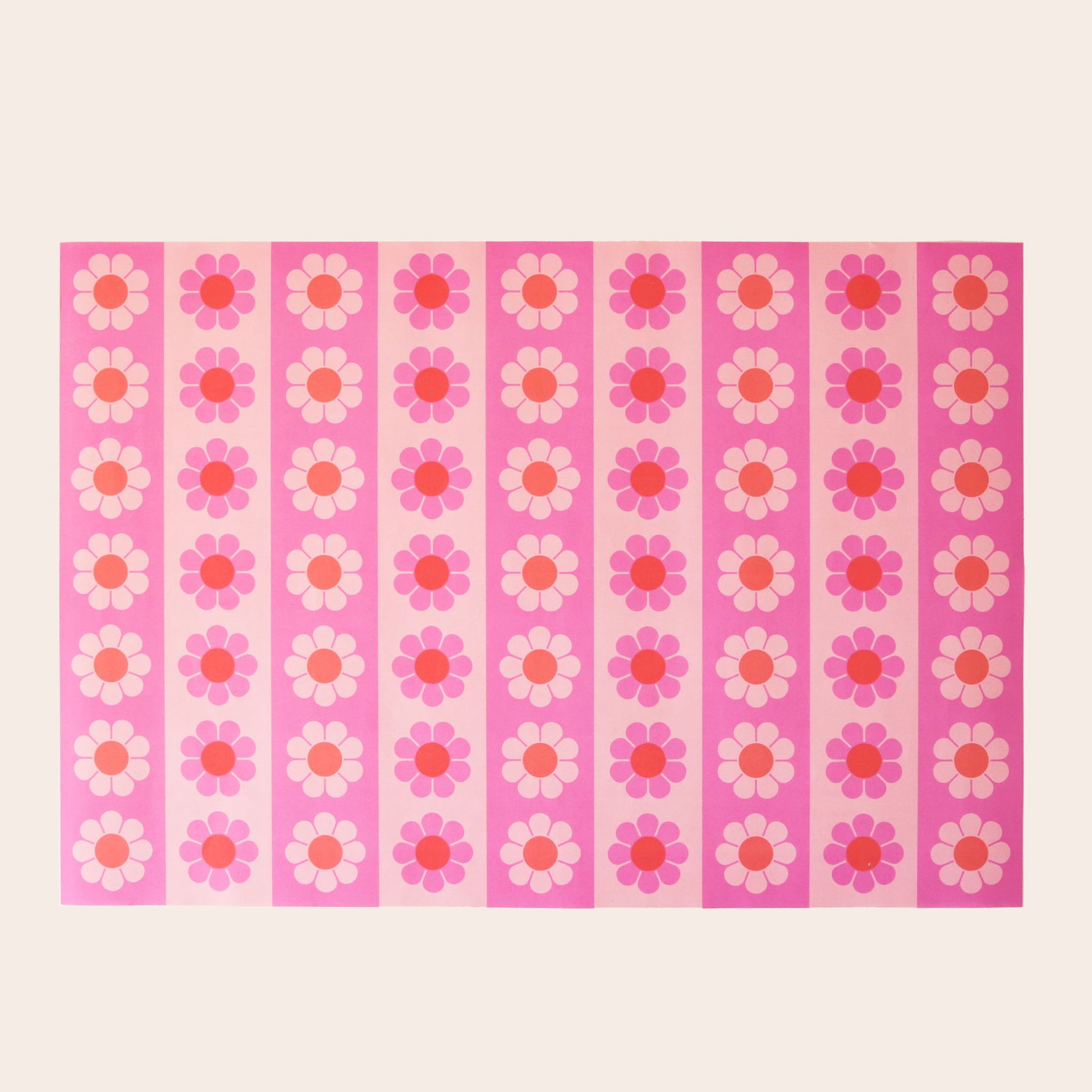 Sheet of wrapping paper filled with vertical stripes of pink and orange flowers. 