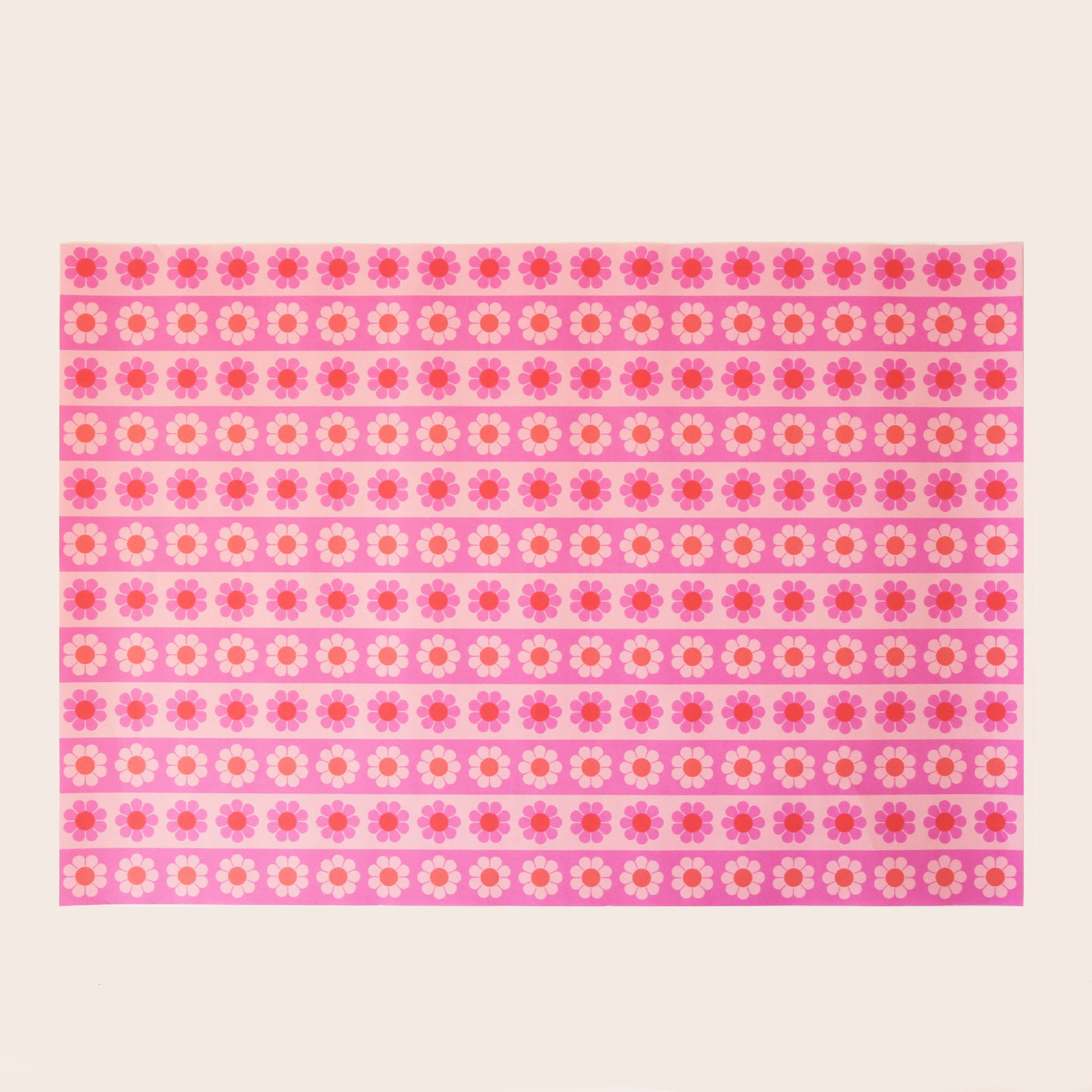 Sheet of wrapping paper filled with horizontal stripes of pink and orange flowers. 