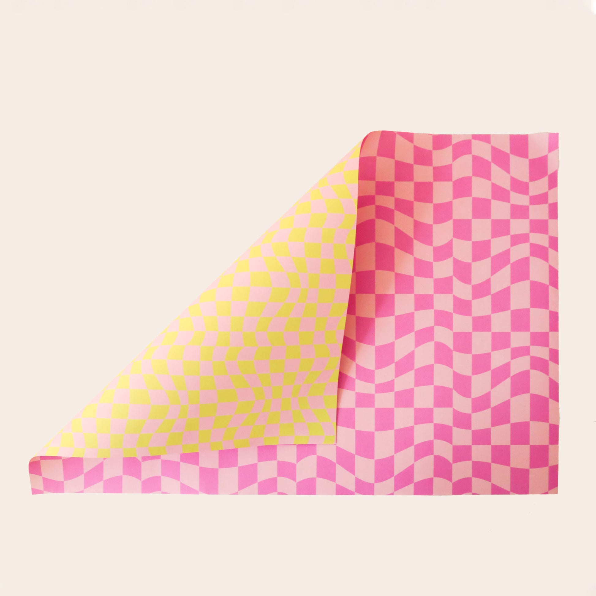 Sheet of distorted pink checkered wrapping paper. The sheet is bent forward, revealing the other side of the wrapping paper. The back side is covered in distorted yellow and pink checkered print.
