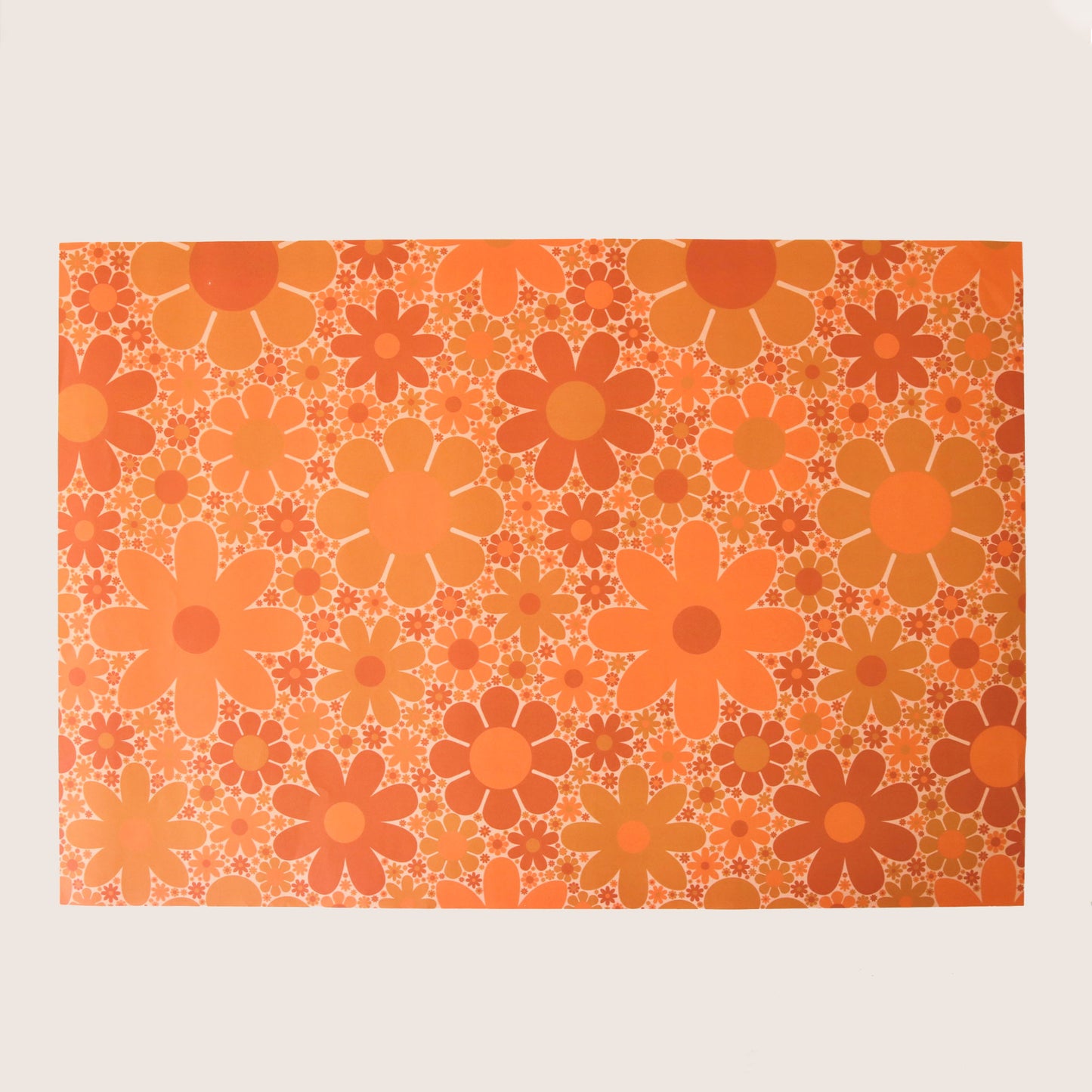 Sheet of wrapping paper filled with orange and yellow flowers of various shapes and sizes.