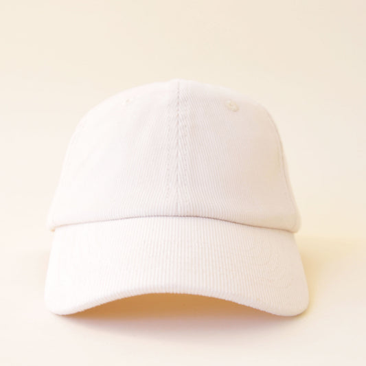 An ivory colored corduroy baseball hat with embroidered lettering that reads, "MAMA" in white across the front.