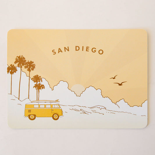 A peach postcard with palm trees and a VW bus with surfboards on the top of it. The text says, "San Diego".