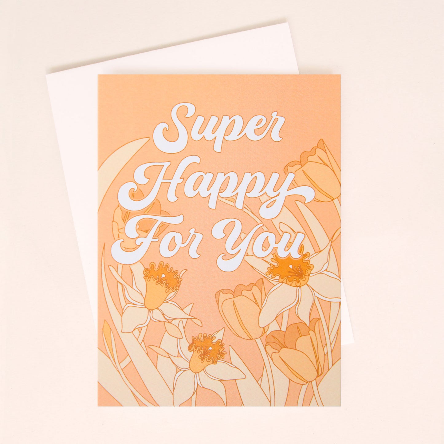 A peach colored card with a white envelope and white bubble cursive text that reads, "Super Happy For You" along with tulip and daffodil illustrations on lining the middle and bottom.