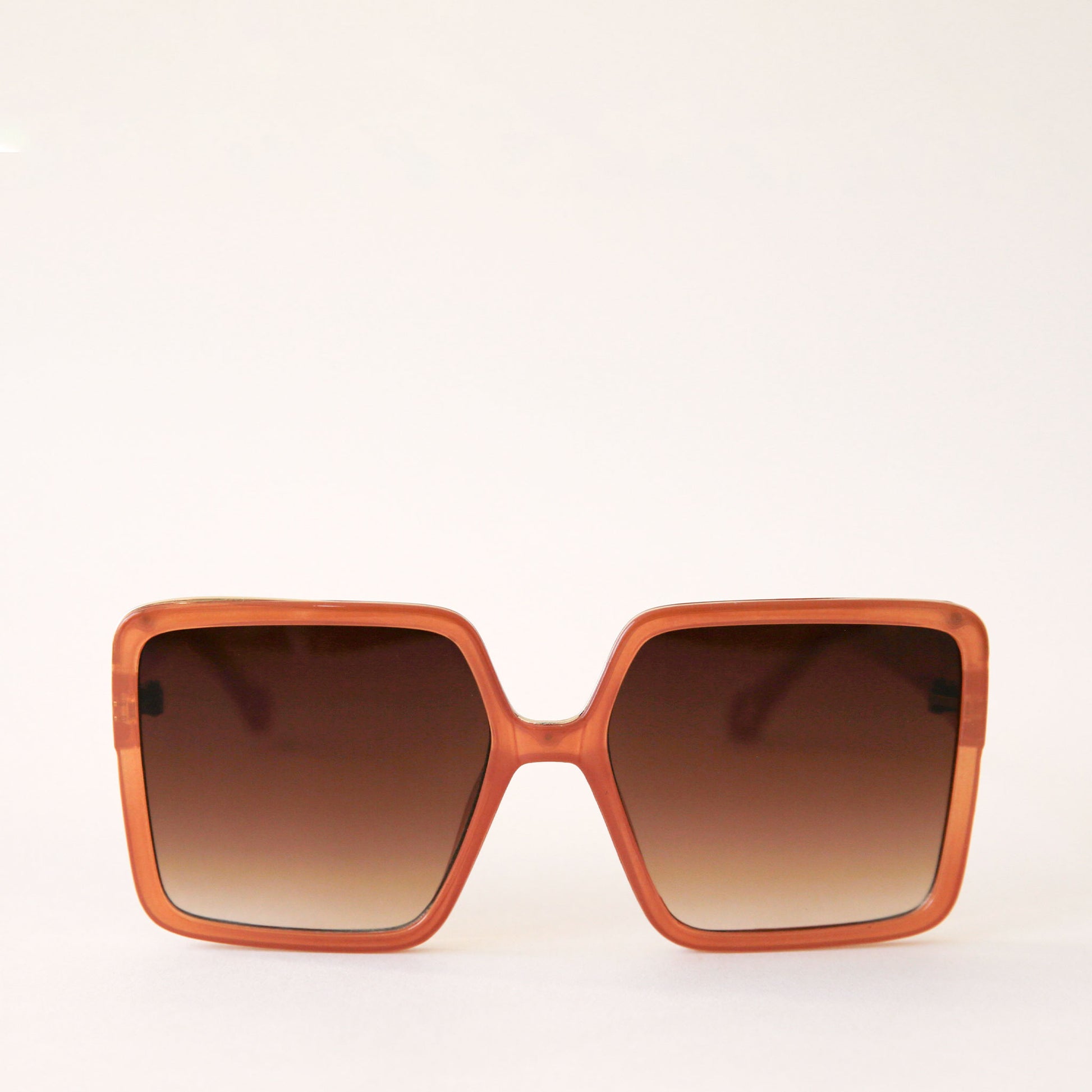 70's inspired square sunglasses with an oversized cognac colored frame and a brown lens.