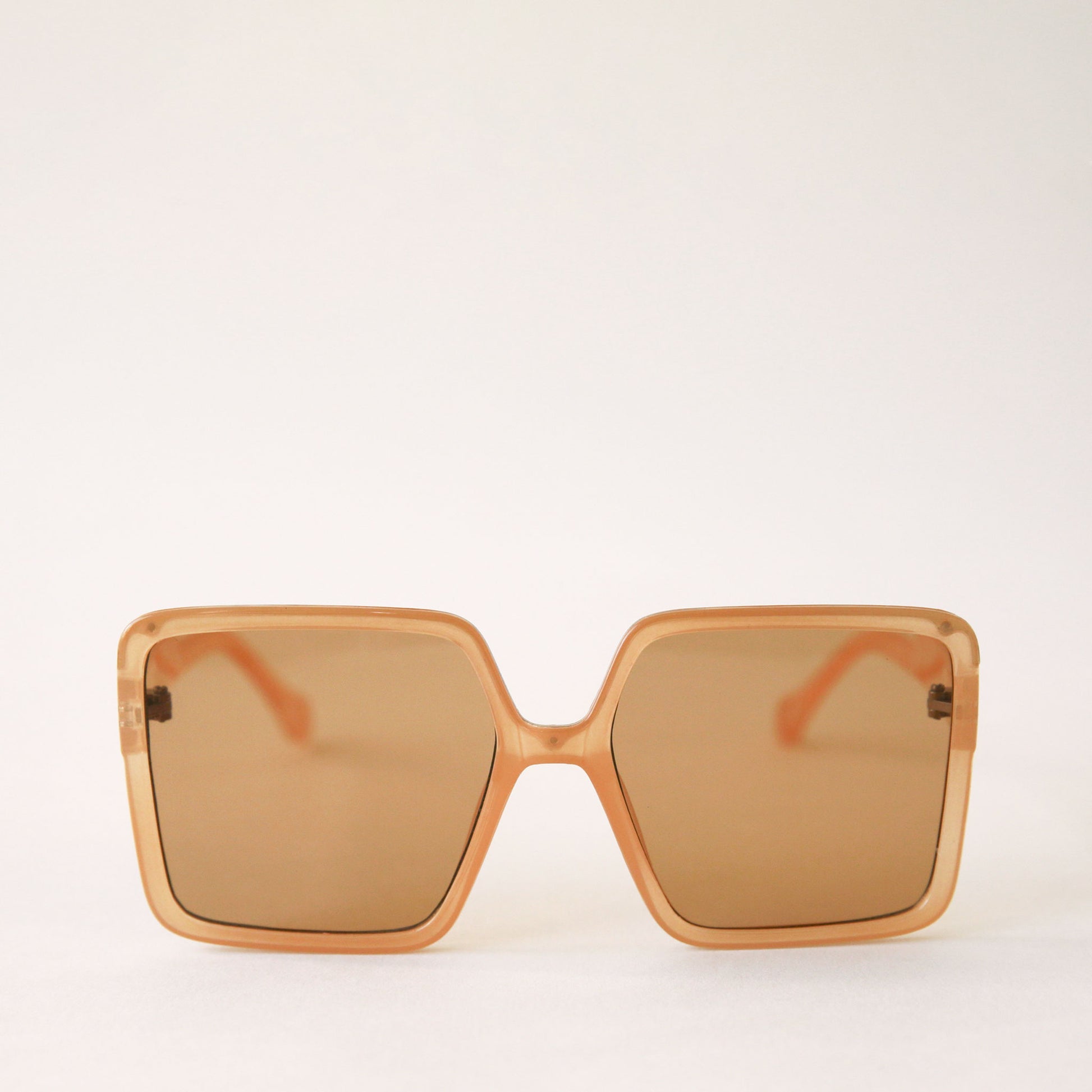 70's inspired square sunglasses with an oversized tan frame and tannish / orange lenses.