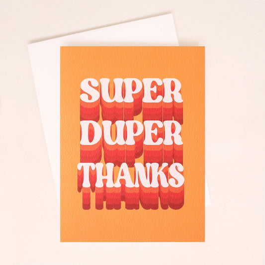 Sitting on top of a white envelope is an orange card. There are large 70’s inspired white text that reads ‘super duper thanks.’ Behind each word is a shadow to make the words look like they are moving off the card. The shadow starts out as a light orange and becomes darker at the bottom.