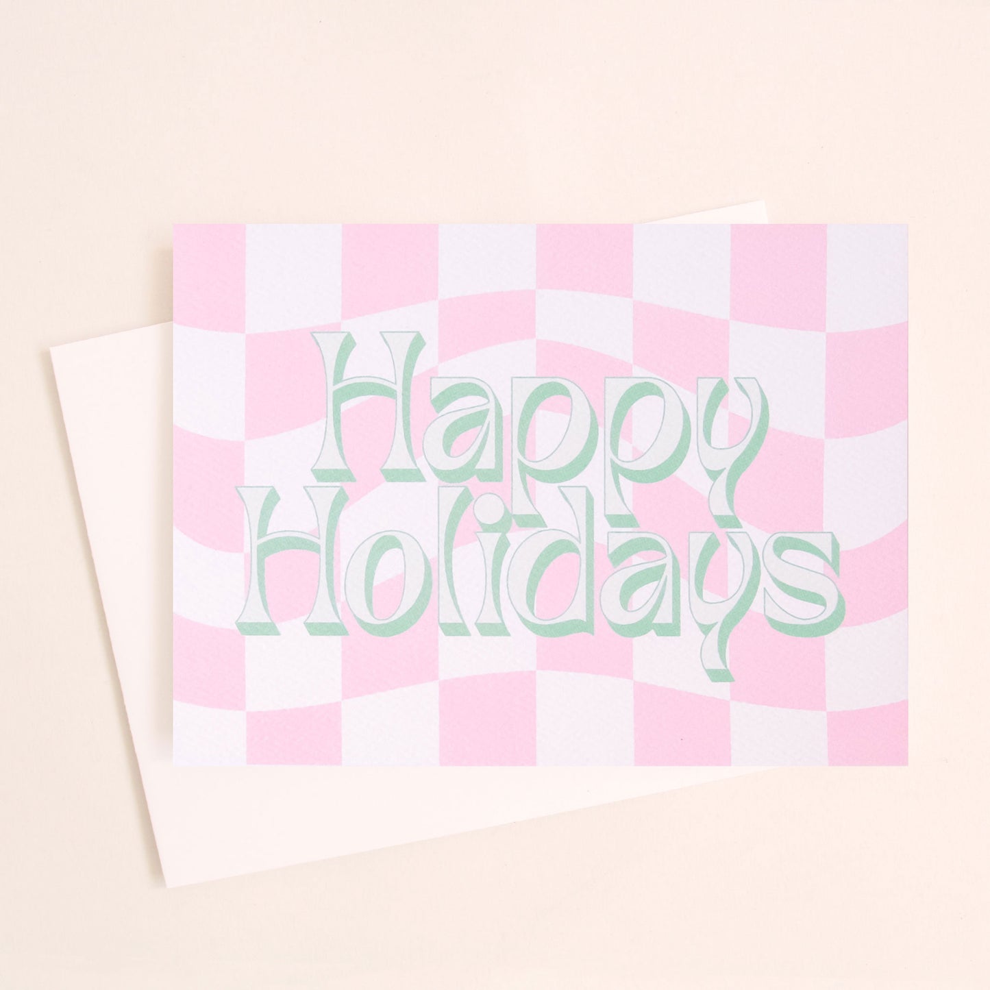 A pink and white checkered card with green and ivory text that reads, "Happy Holidays".
