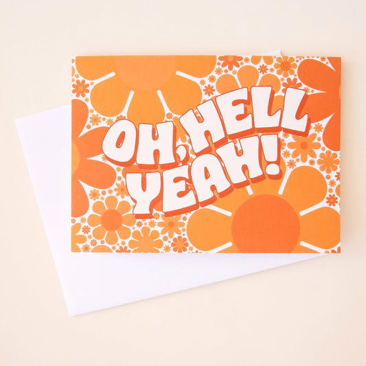 Card filled retro bus flower design in various shades of orange. The card reads 'oh, hell yeah!' across the card in curved white bubble letters and is accompanied by a solid white envelope. 