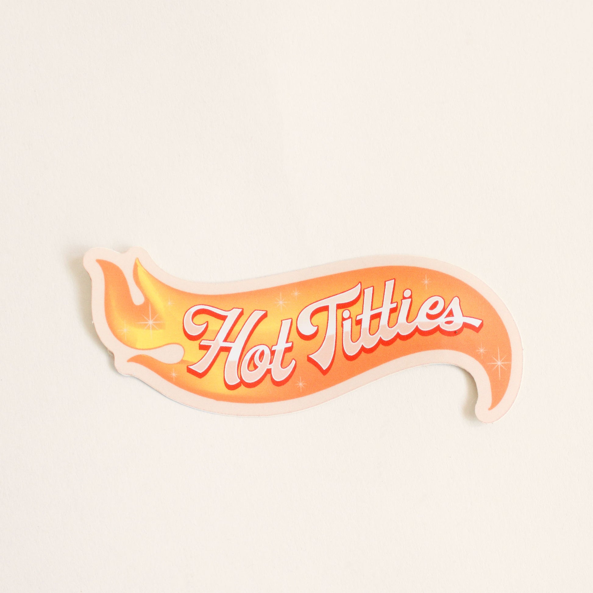 Flame sticker reading 'Hot titties' in white cursive text. The lettering is accented in red and is placed across the flame design.
