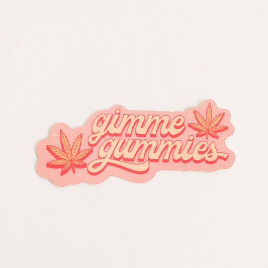 pink sticker with two yellow and dark pink colored weed leaves and light yellow text reading 'gimme gummies'