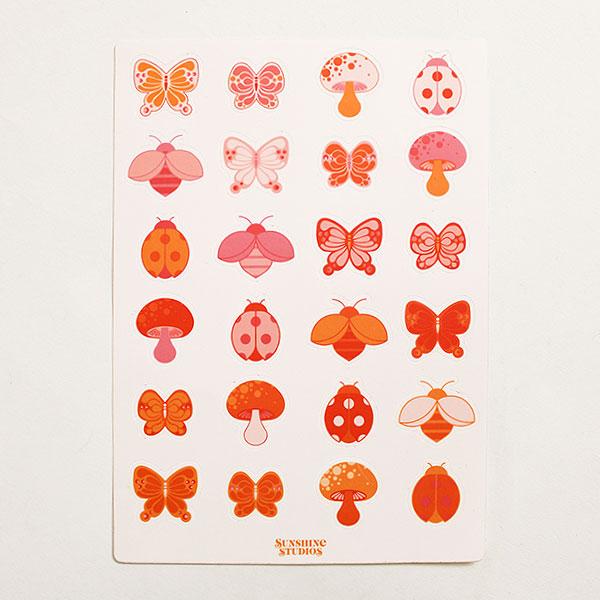 White sticker sheet filled with rows of vibrantly pink bugs and mushrooms. The sticker sheet is filled with oranges, reds and pinks. 
